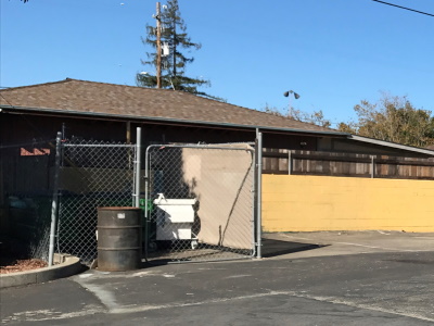 a fenced trash storage area